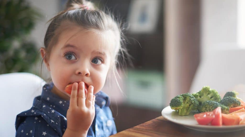 Nena comiendo brocoli