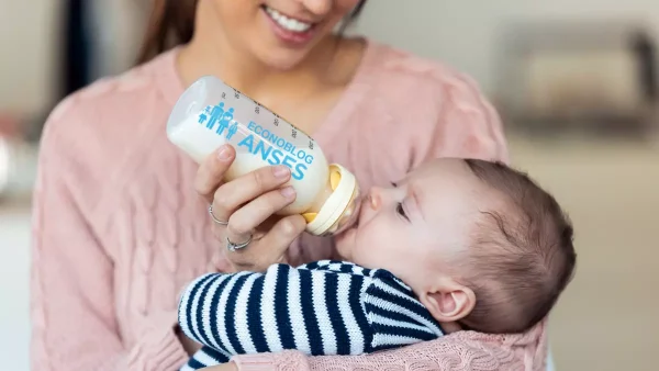 Bebé de la AUH tomando leche en mamadera de Anses