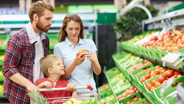 Familia comprando tomates en supermercado