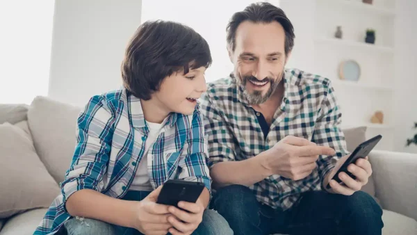 Padre e hijo con sus teléfonos celulares