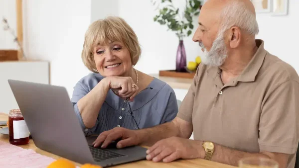 Jubilados hablando frente a una computadora