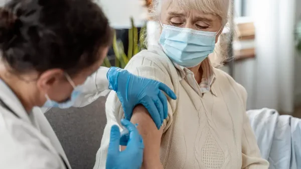 Doctora aplicando una vacuna a una jubilada