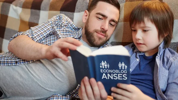 Padre e hijo leyendo libro de Anses sobre AUH y SUAF