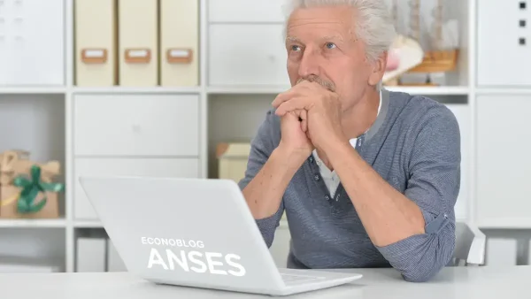 Jubilado de la Anses pensando frente a su computadora