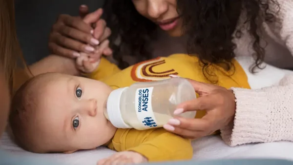Bebé de la AUH de Anses siendo alimentado con leche por su madre
