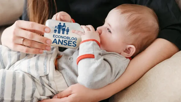 Bebé de la AUH tomando leche con mamadera de Anses