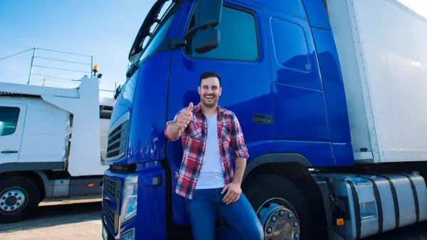 Camionero contento frente a su camión