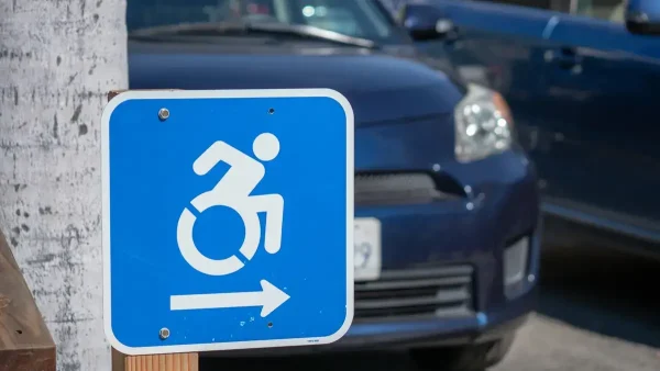 Símbolo de discapacidad en un estacionamiento con autos