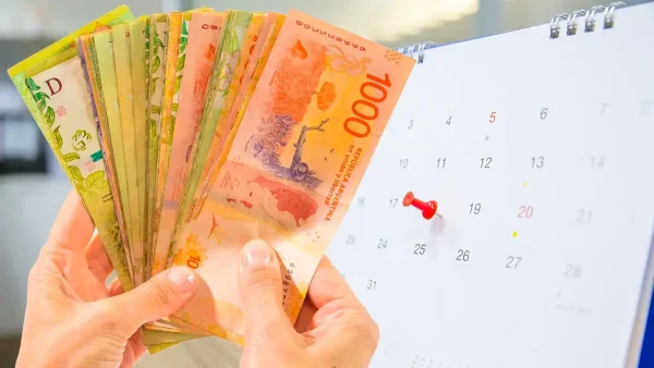 Billetes de pesos argentinos junto a un calendario