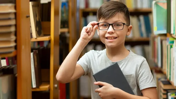 Estudiante con anteojos y un libro en la mano