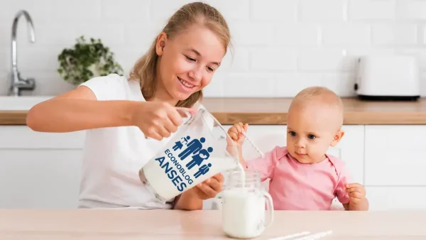 Bebé de la AUH con jarra de leche de Anses