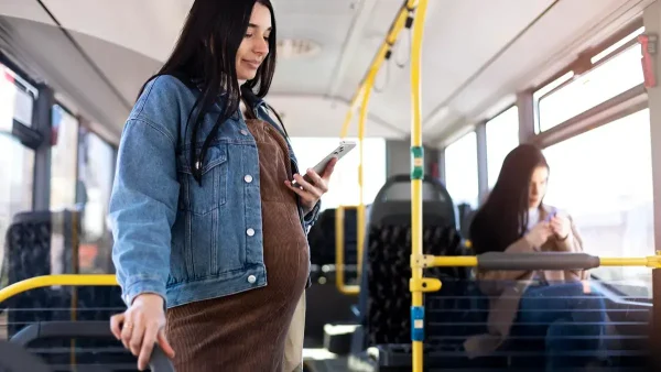 Mujer embarazada viajando en colectivo