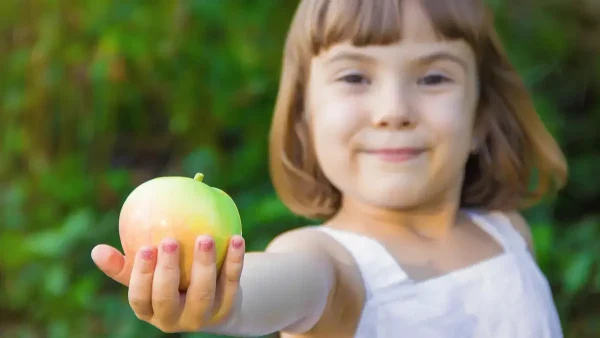 Niña con una manzana en la mano