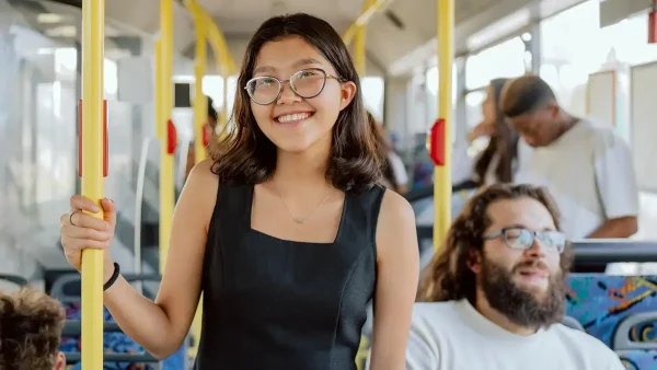 Joven sonriente viajando en un colectivo